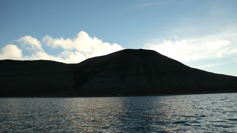 Johan Hjortfjellet sett fra sjøen på østsiden og med  motlys.
