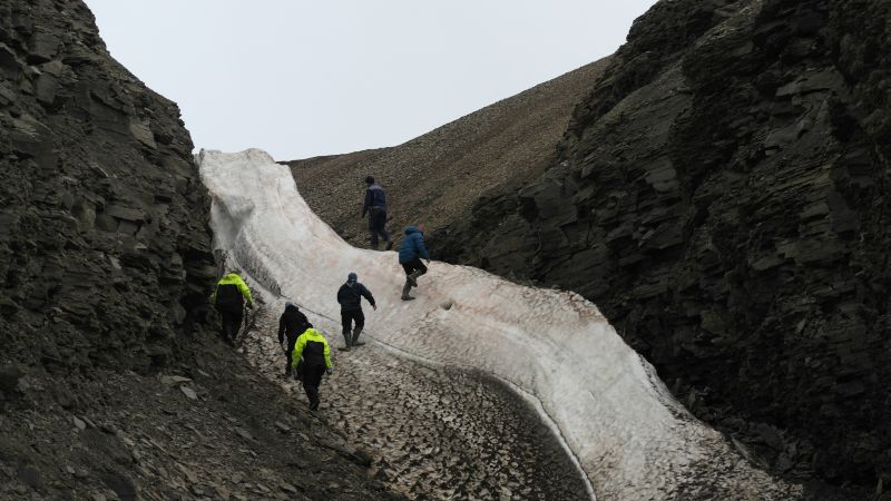 Besøkende klatrer opp snøfonna i bunnen av skaret.