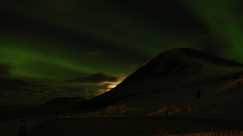 Werenskioldfjellet og Iversenfjellet i nordlys og månen er i ferd med å forsvinne bak Werenskiold.